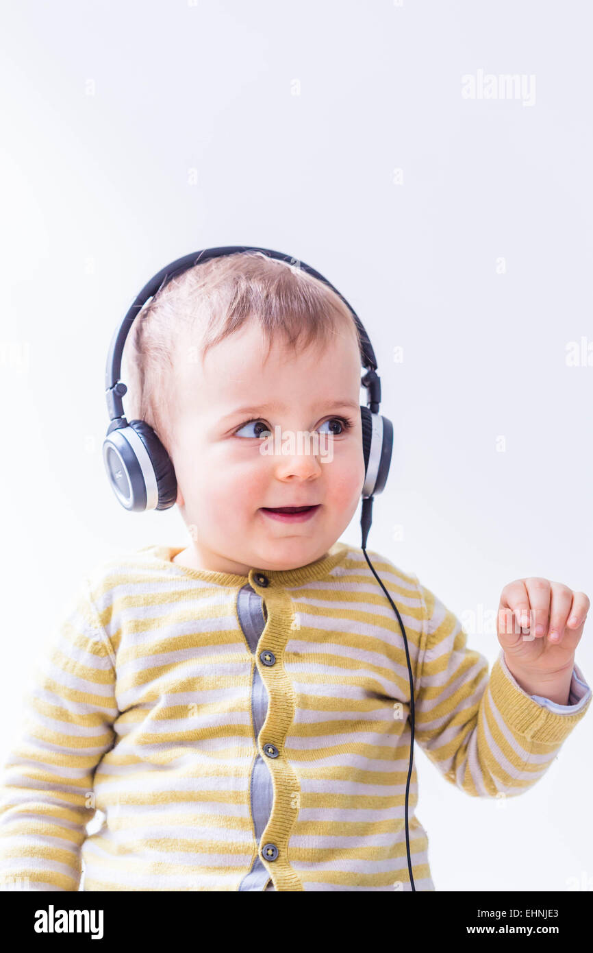 18 Monate altes Baby junge Musik hören. Stockfoto