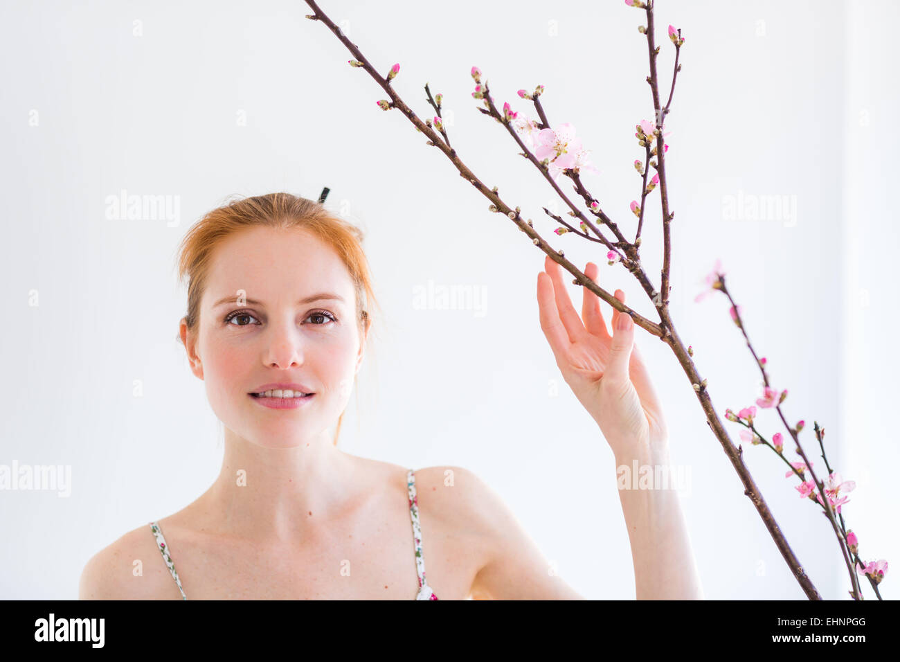 Frau vor einem Blooning Prunus Zweig. Stockfoto