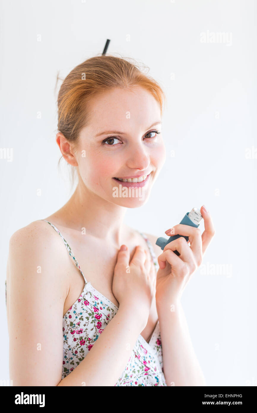 Frau mit einem Aerosol-Inhalator, der Erweiterung der Bronchien zur Behandlung von Asthma enthält. Stockfoto