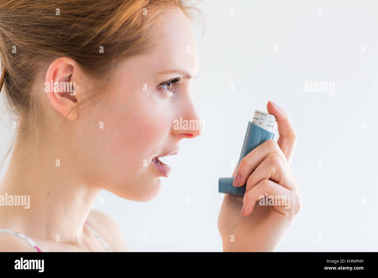 Frau mit einem Aerosol-Inhalator, der Erweiterung der Bronchien zur Behandlung von Asthma enthält. Stockfoto