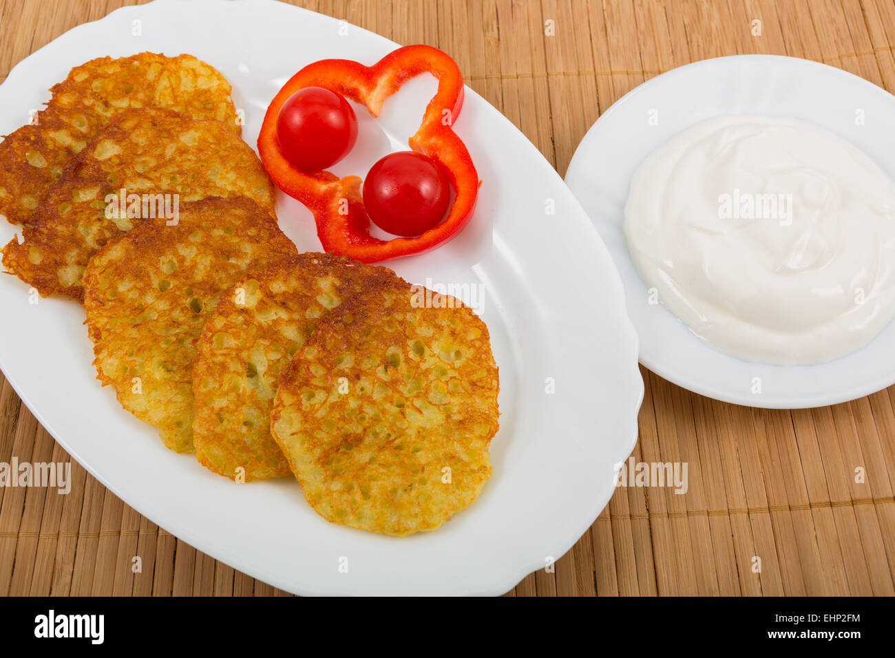 Kartoffelpuffer mit Gemüse und Sauerrahm Stockfoto