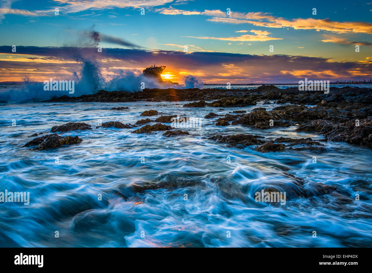 Wellen und Felsen bei Sonnenuntergang, am kleinen Corona Beach in Corona del Mar, Kalifornien. Stockfoto