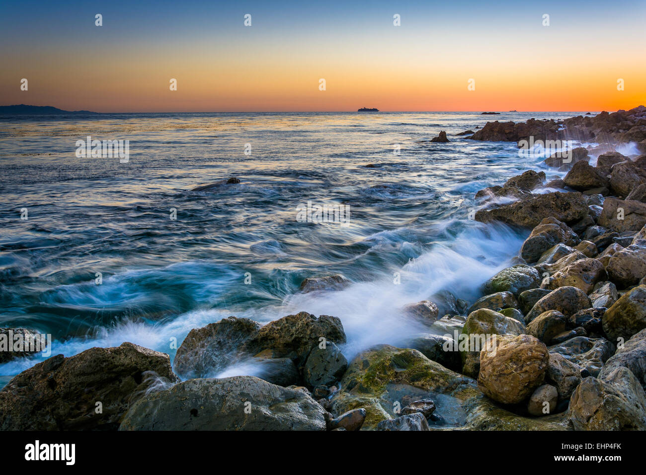 Wellen, auf Felsen am Pelican Cove bei Sonnenuntergang in Rancho Palos Verdes, Kalifornien. Stockfoto