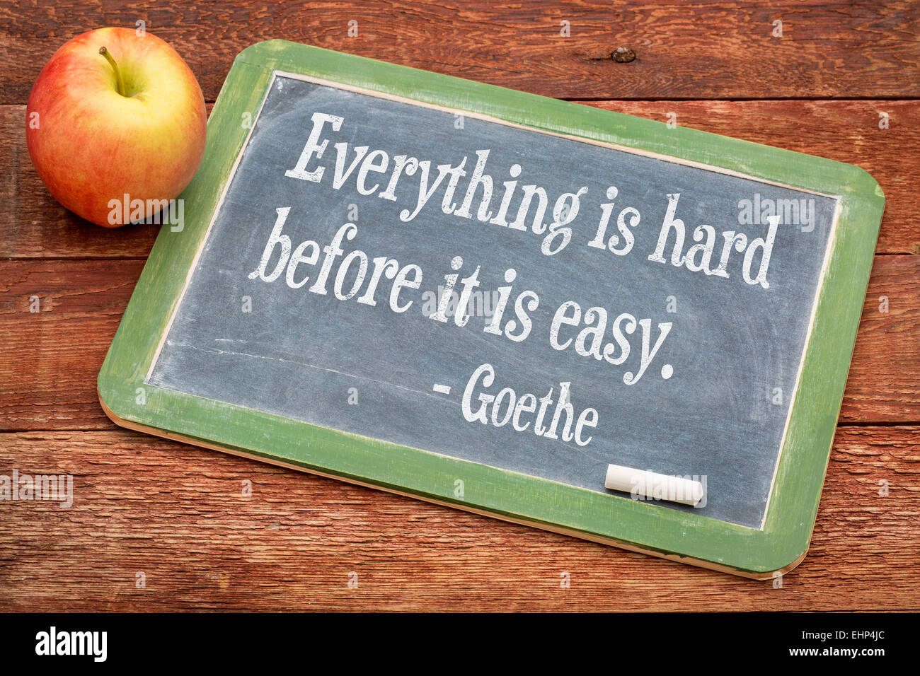 Alles ist schwer, bevor es leicht - ist Goethe-Zitat auf einer Schiefertafel Tafel gegen rote Scheune Holz Stockfoto