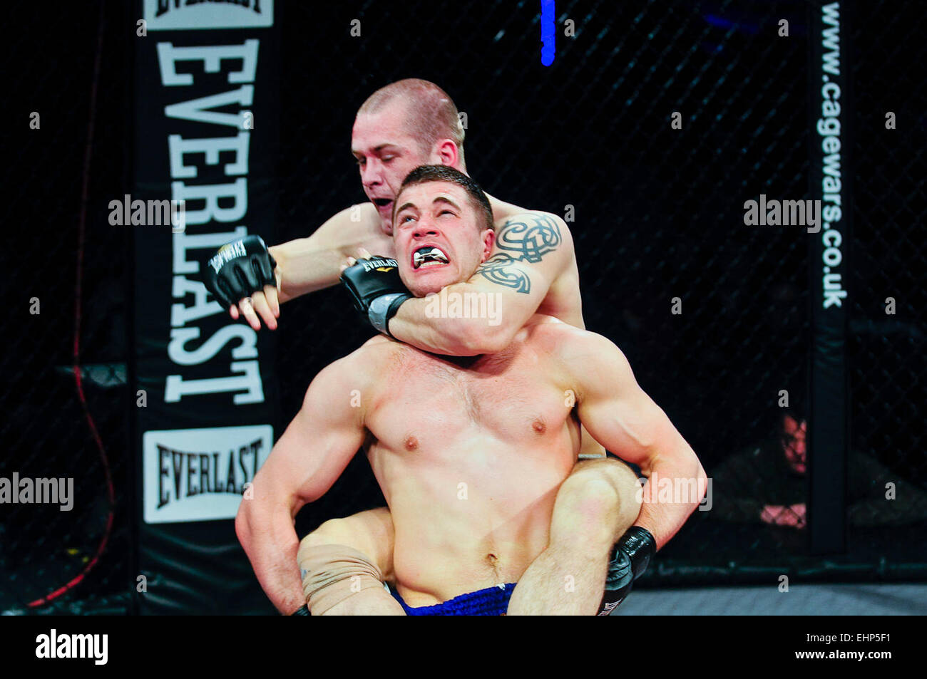 MMA Käfig-Kämpfer setzt seinen Gegner in einen Würgegriff mit seinen Arm um den Hals. Stockfoto