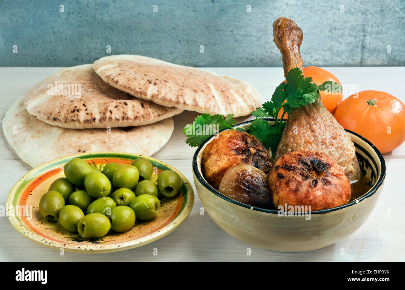 Marokkanische Ente Bein Tajine mit Mandarinen, Zwiebeln und frischer Koriander, serviert mit Pita Brot und grünen Oliven. Stockfoto