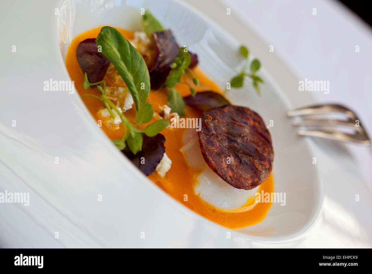 Ei, Butternut Creme, Popcorn und Chorizo-chips Stockfoto