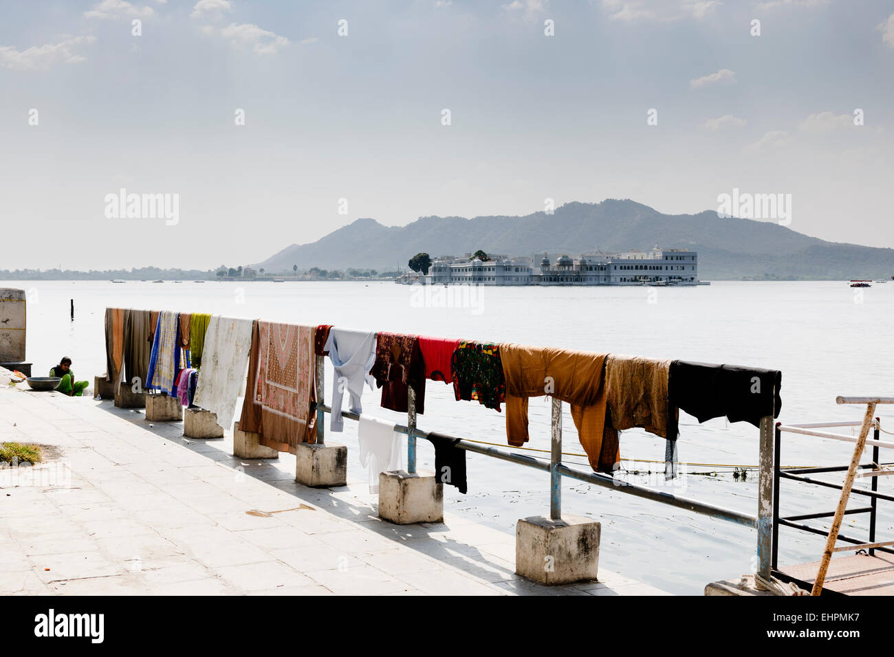 Waschen, trocknen mit Taj Lake Palace im Hintergrund, Udaipur. Stockfoto