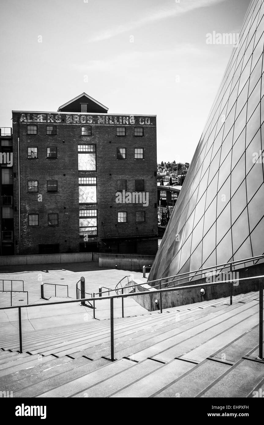 Der historische rote Backsteinbau Albers Bros. Fräsen Co. steht neben der zeitgenössischen Fassade des Tacoma Glasmuseum. Stockfoto