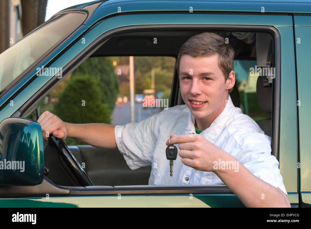 Junger Mann in einem Auto mit dem Schlüssel Stockfoto