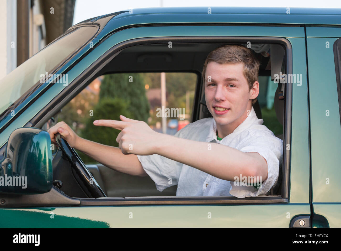 junger Mann in einem Auto lächelnd 2 Stockfoto