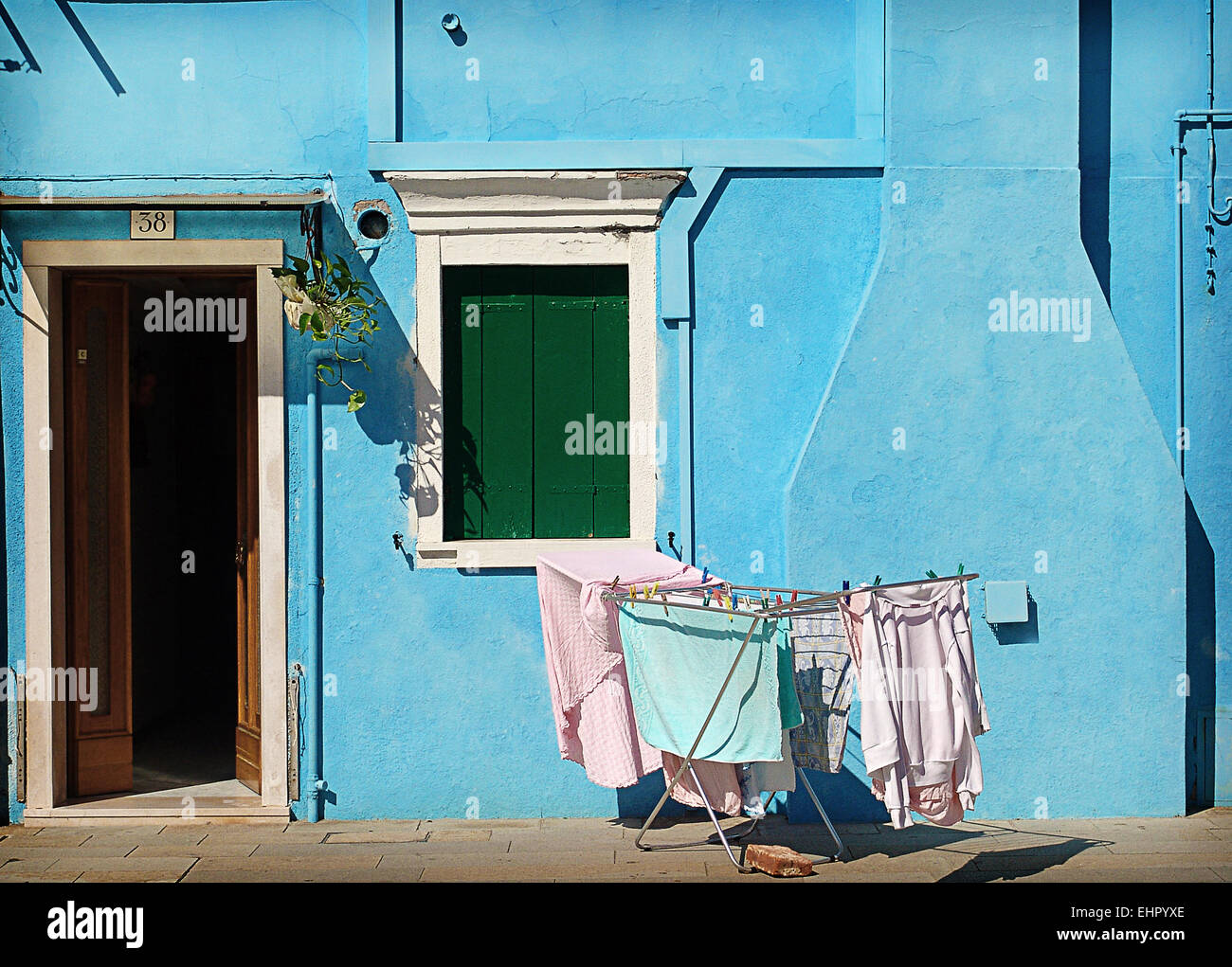 Ein schöner Tag des Septembers in Burano, ein kleines blaues Haus mit der Wäsche in der Sonne, ein ruhiger Ort zum übernachten. Stockfoto