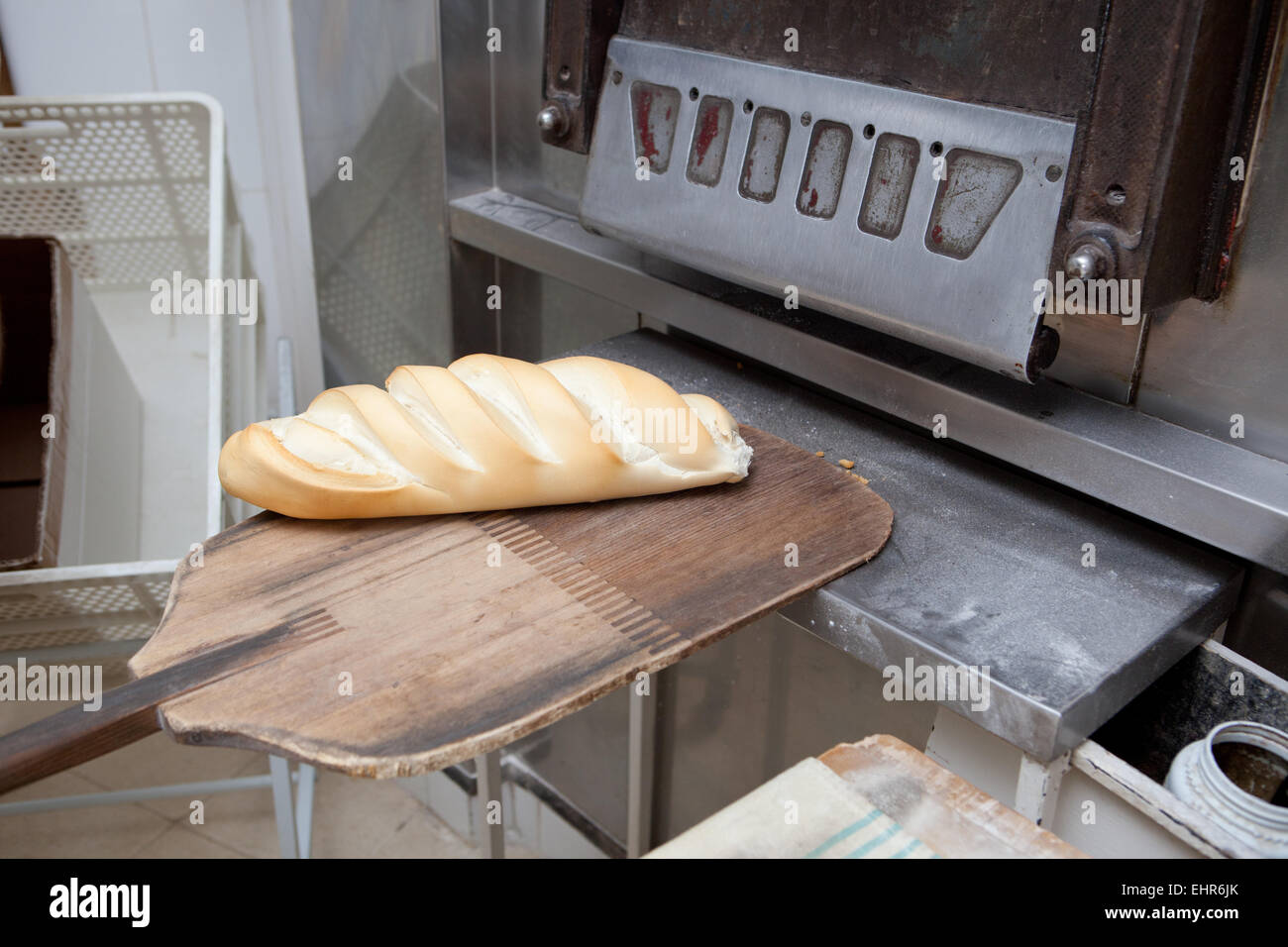 Bäcker, frisches gebackenes Brot aus dem Ofen nehmen. Herstellungsprozess der spanischen Brot Stockfoto