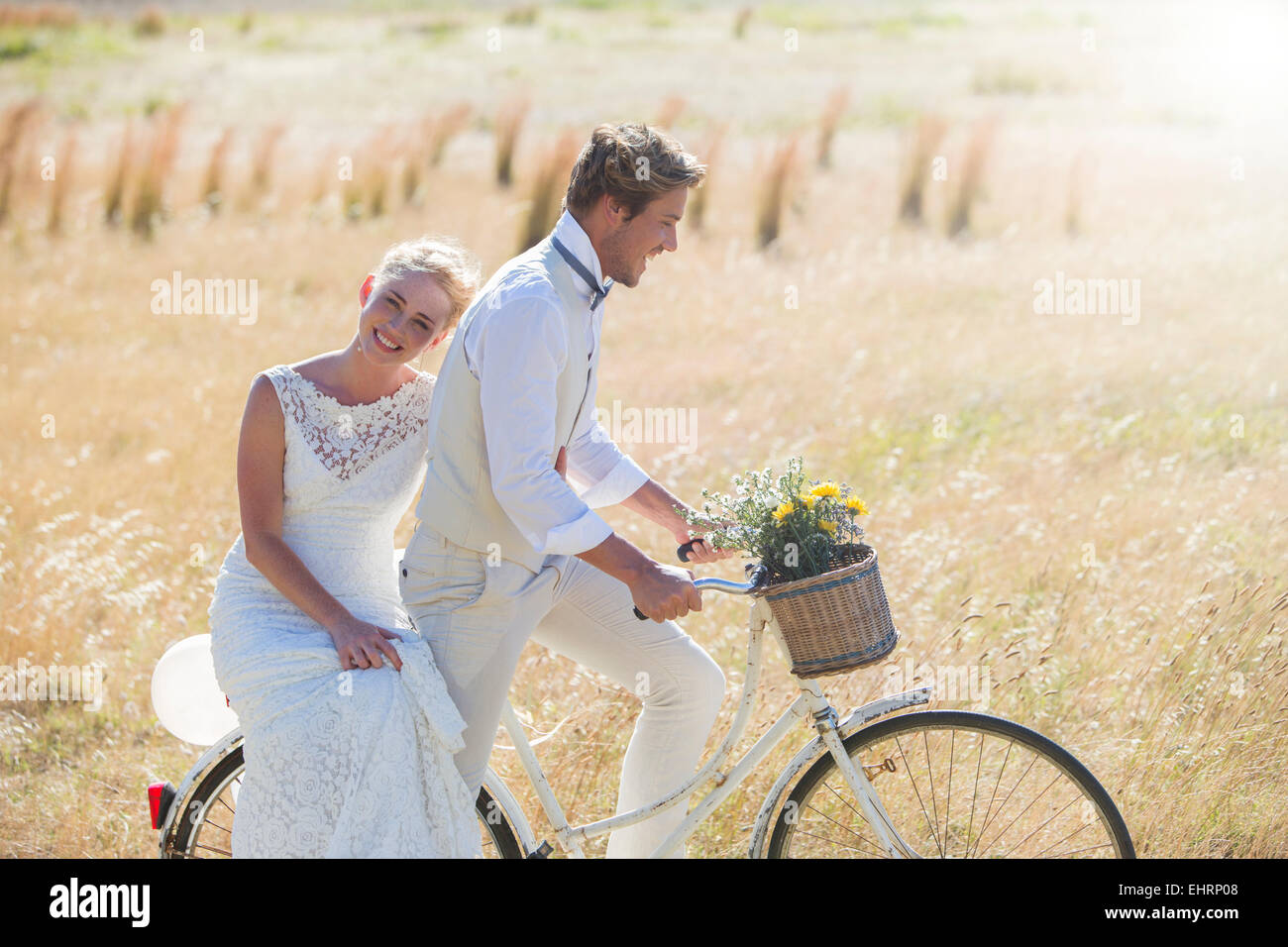 Junges Paar Reiten Fahrrad auf Wiese Stockfoto