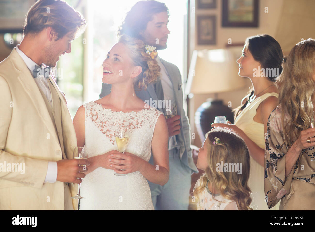 Junges Paar mit Gästen und Sektgläser bei Hochzeitsfeier Stockfoto