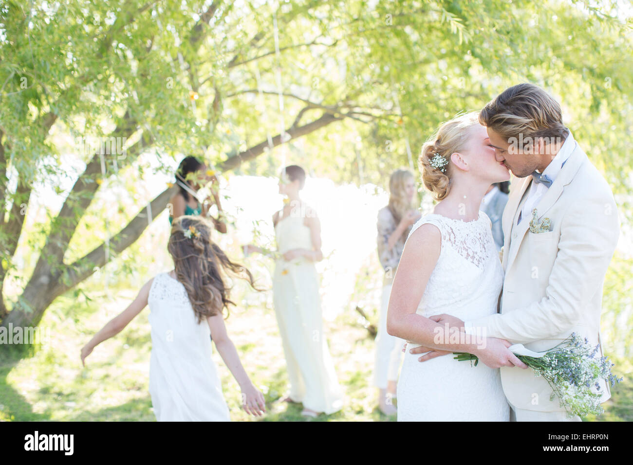 Junge Paar küssen bei Hochzeitsfeier im heimischen Garten Stockfoto