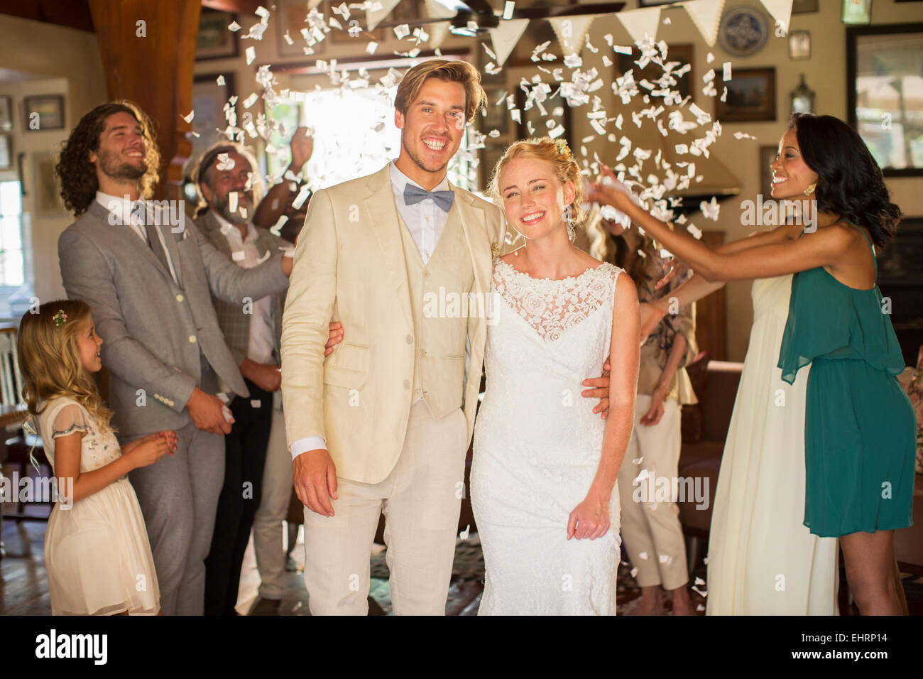 Porträt des Lächelns in fallenden Konfetti junges Paar stehen während der Hochzeitsfeier Stockfoto