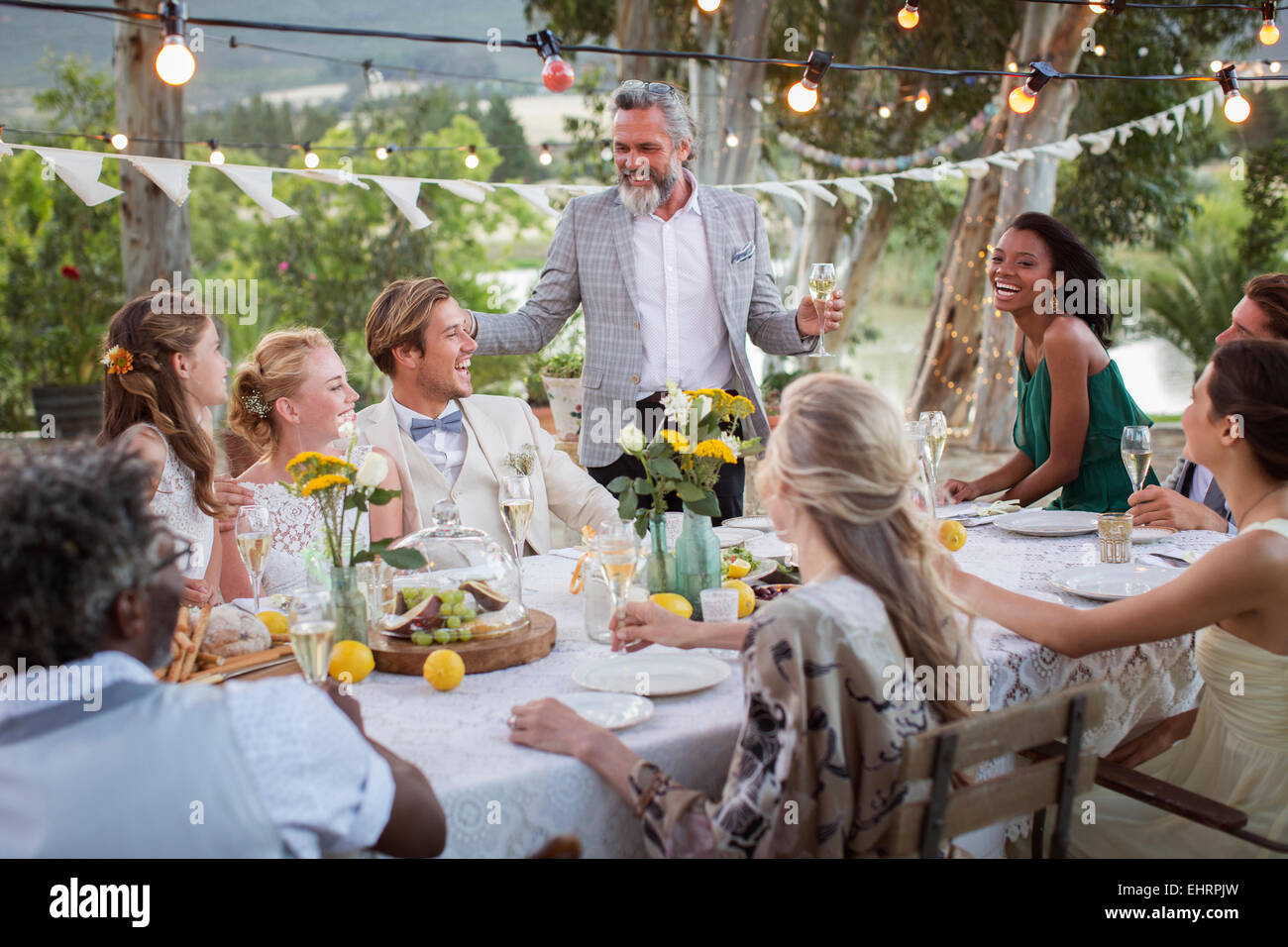 Trauzeuge sprechen während der Hochzeitsfeier im heimischen Garten Stockfoto