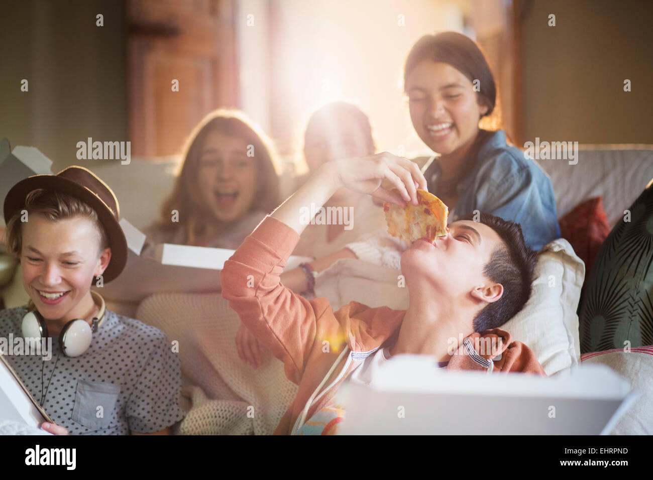 Gruppe von Jugendlichen Essen Pizza auf Sofa im Wohnzimmer Stockfoto