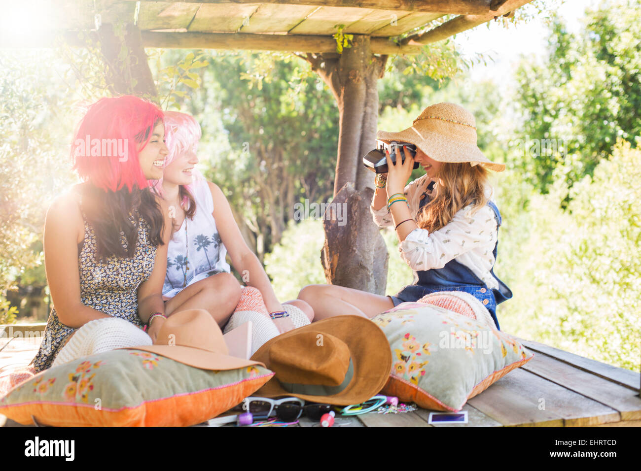 Drei Mädchen im Teenageralter fotografieren im Baumhaus im Sonnenlicht Stockfoto