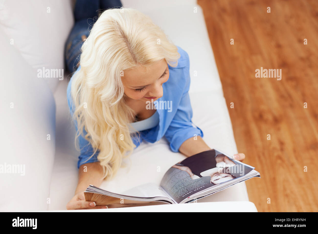 Frau auf Couch liegen und lesen zu Hause Magazin Stockfoto
