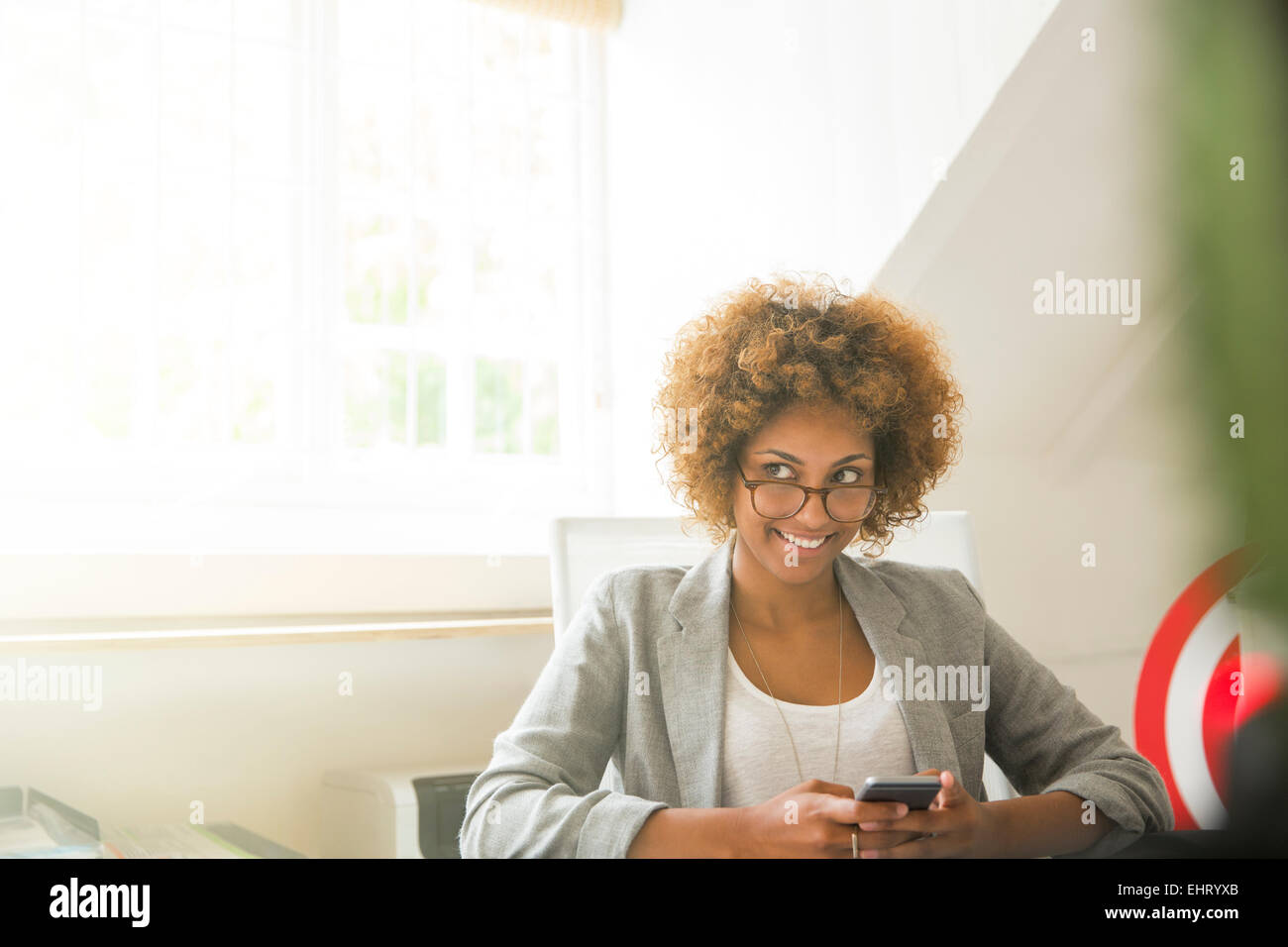 Porträt des Lächelns Büroangestellte mit Smartphone Stockfoto