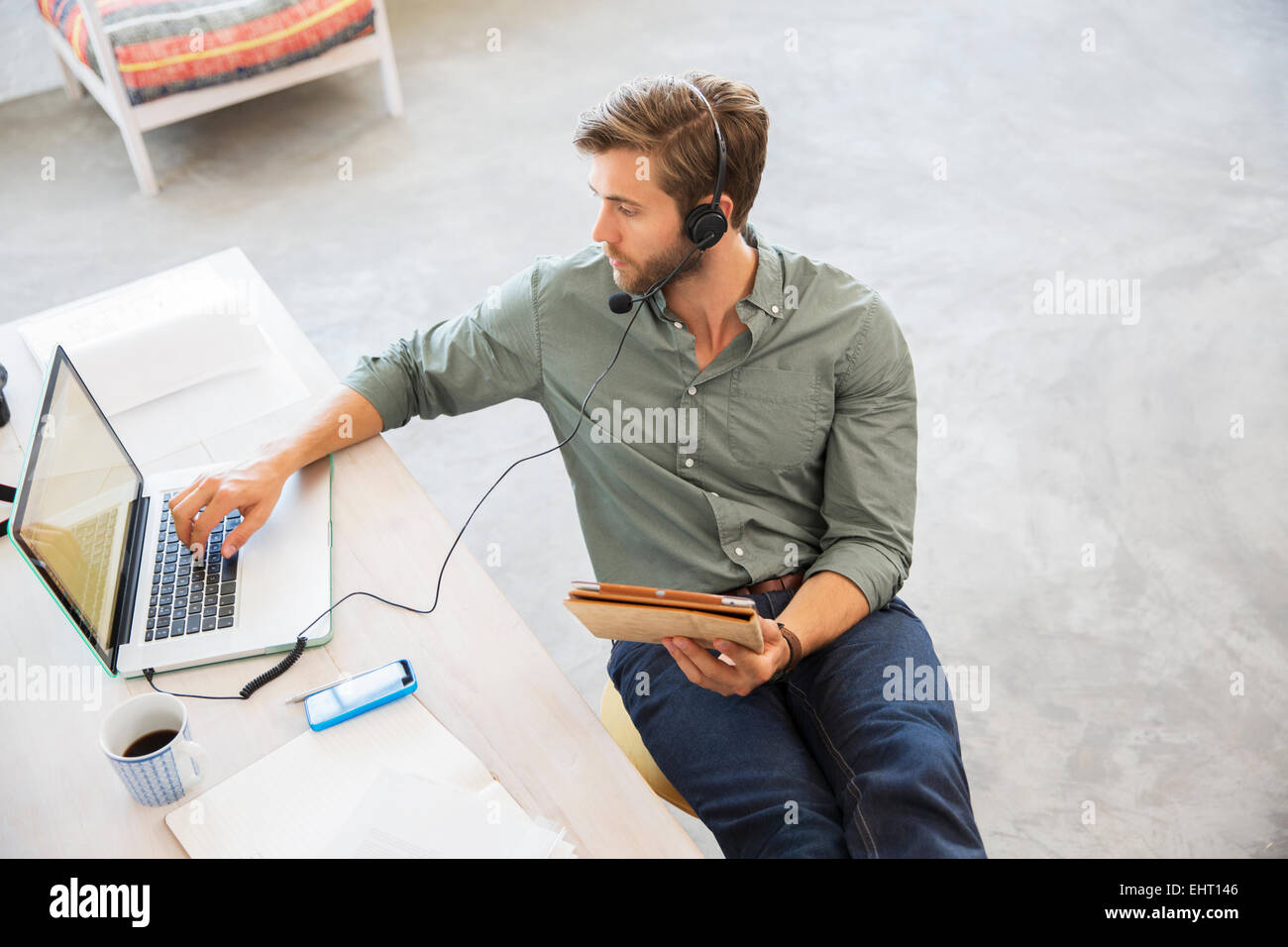 Junger Mann am Schreibtisch arbeiten mit laptop Stockfoto