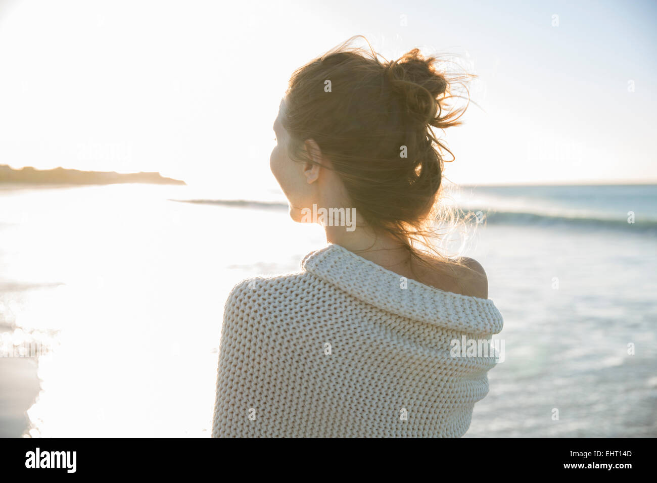 Junge Frau in Decke am Strand gewickelt Stockfoto