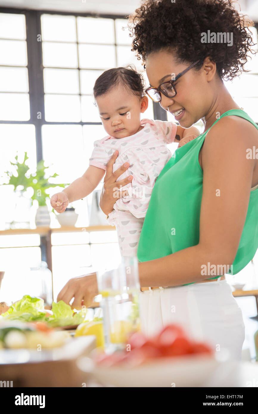 Frau mit Baby Girl Zubereitung in der Küche Stockfoto