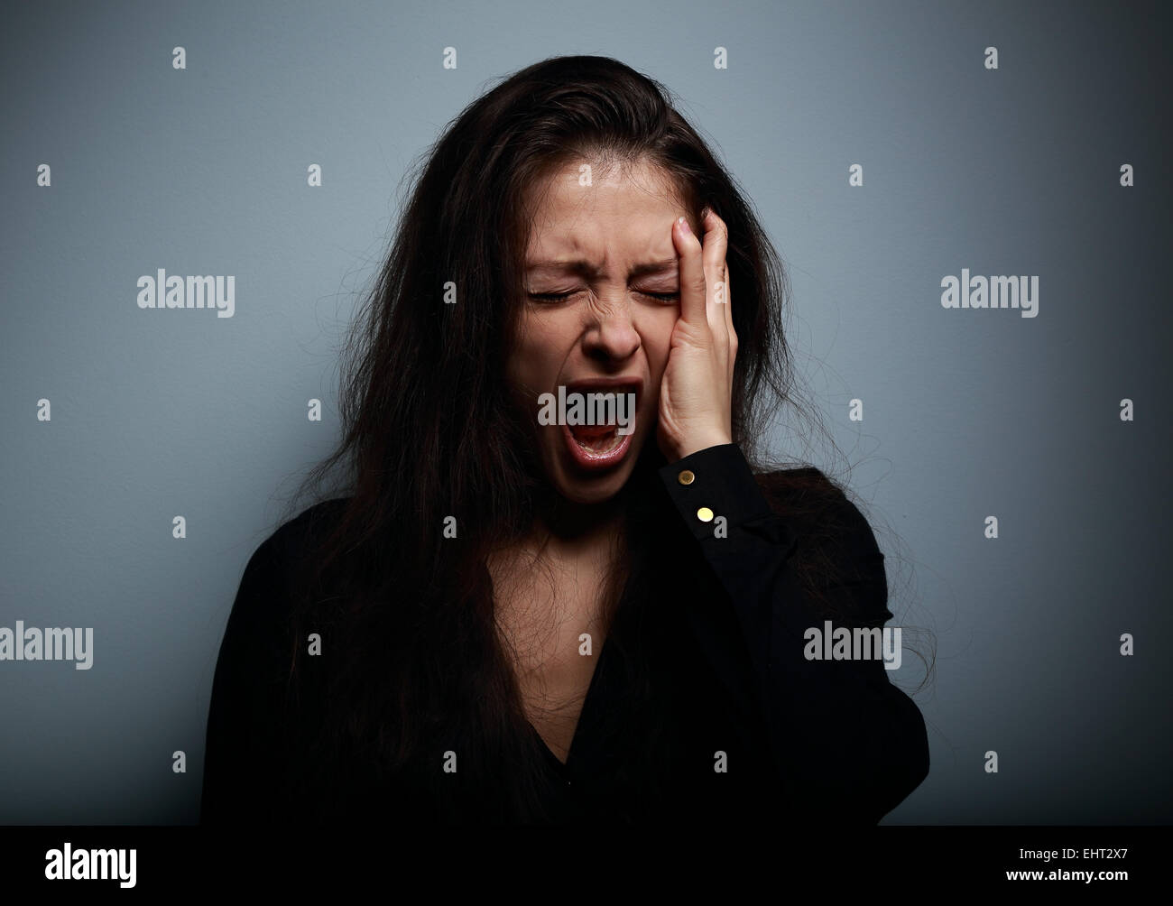 Closeup Portrait Frau wütend, traurig und verzweifelt schreien auf dunklem Hintergrund Stockfoto