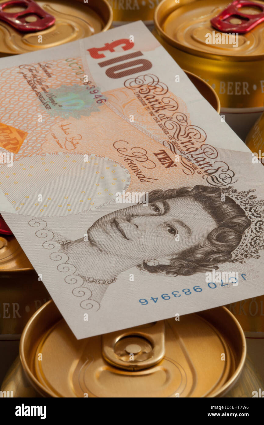England, London - 11. November 2014: Dosen Bier und britische Banknoten. Stockfoto