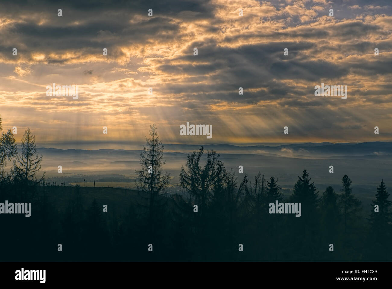 Göttlichen Lichtstrahlen durch Wolken in den frühen Morgenstunden über hügelige Landschaft Stockfoto
