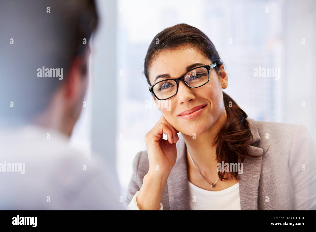 Lächelnde Frau in Gläsern im Büro mit client Stockfoto