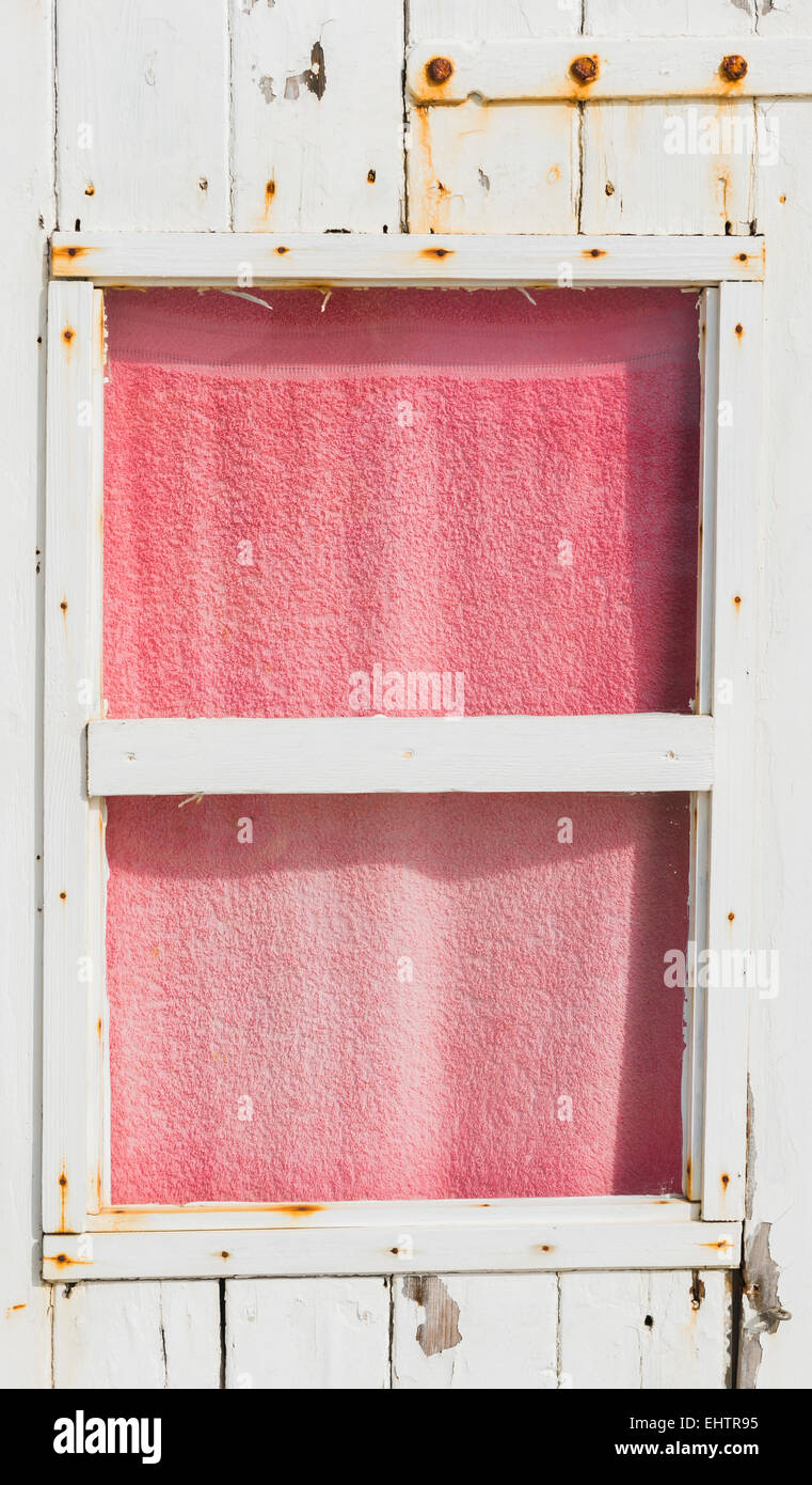 Fenster in Strandkabine mit Handtuch hinter dem Fenster. Stockfoto