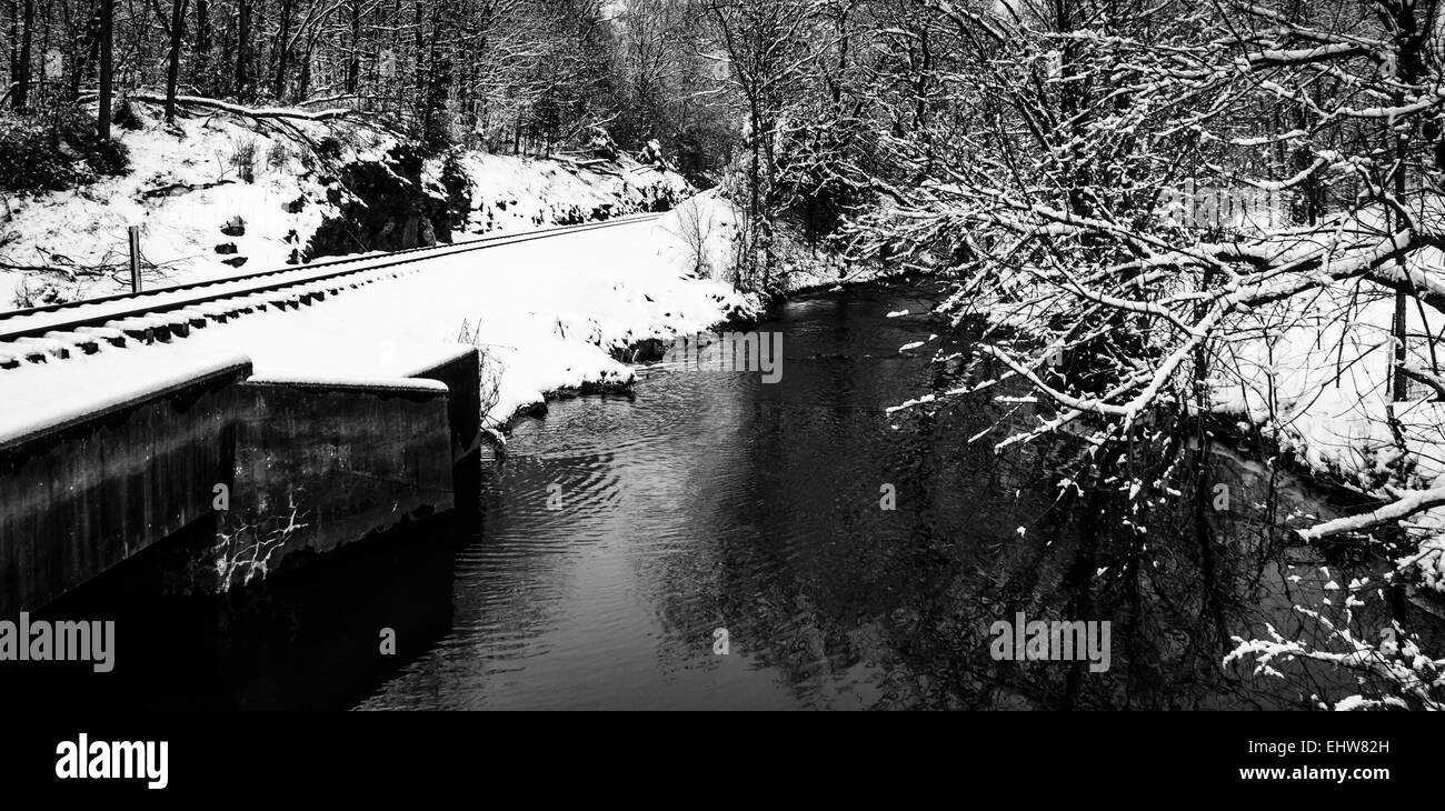 Eisenbahnschienen und Creek während des Winters im ländlichen Carroll County, Maryland. Stockfoto