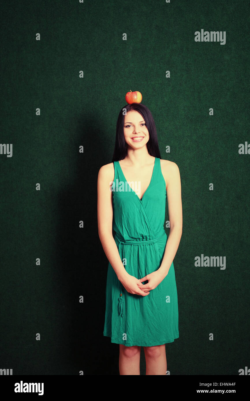 junge Frau mit einem Apfel auf ihrem Kopf Stockfoto