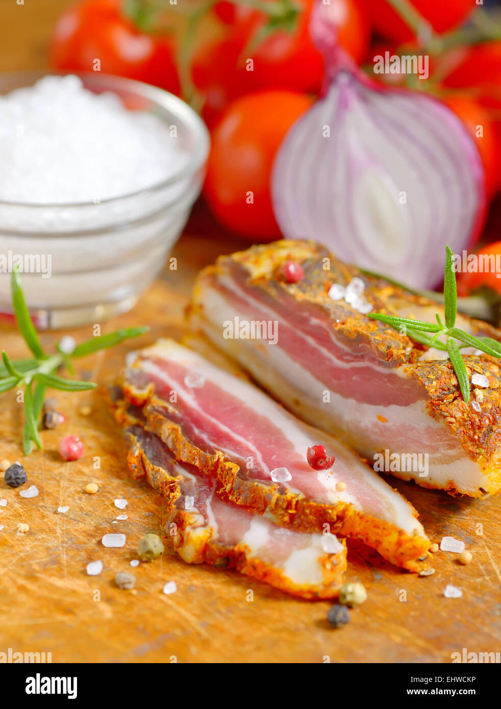 Geräucherter Speck und Gemüse auf Holztisch Stockfoto