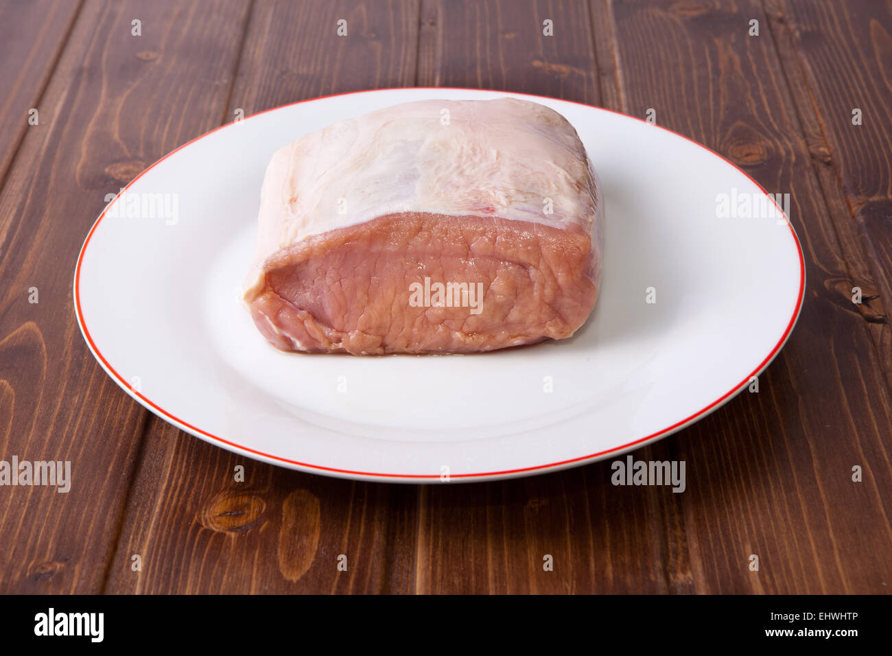 Rohe Lende vom Schwein in Platte über Holzoberfläche Stockfoto