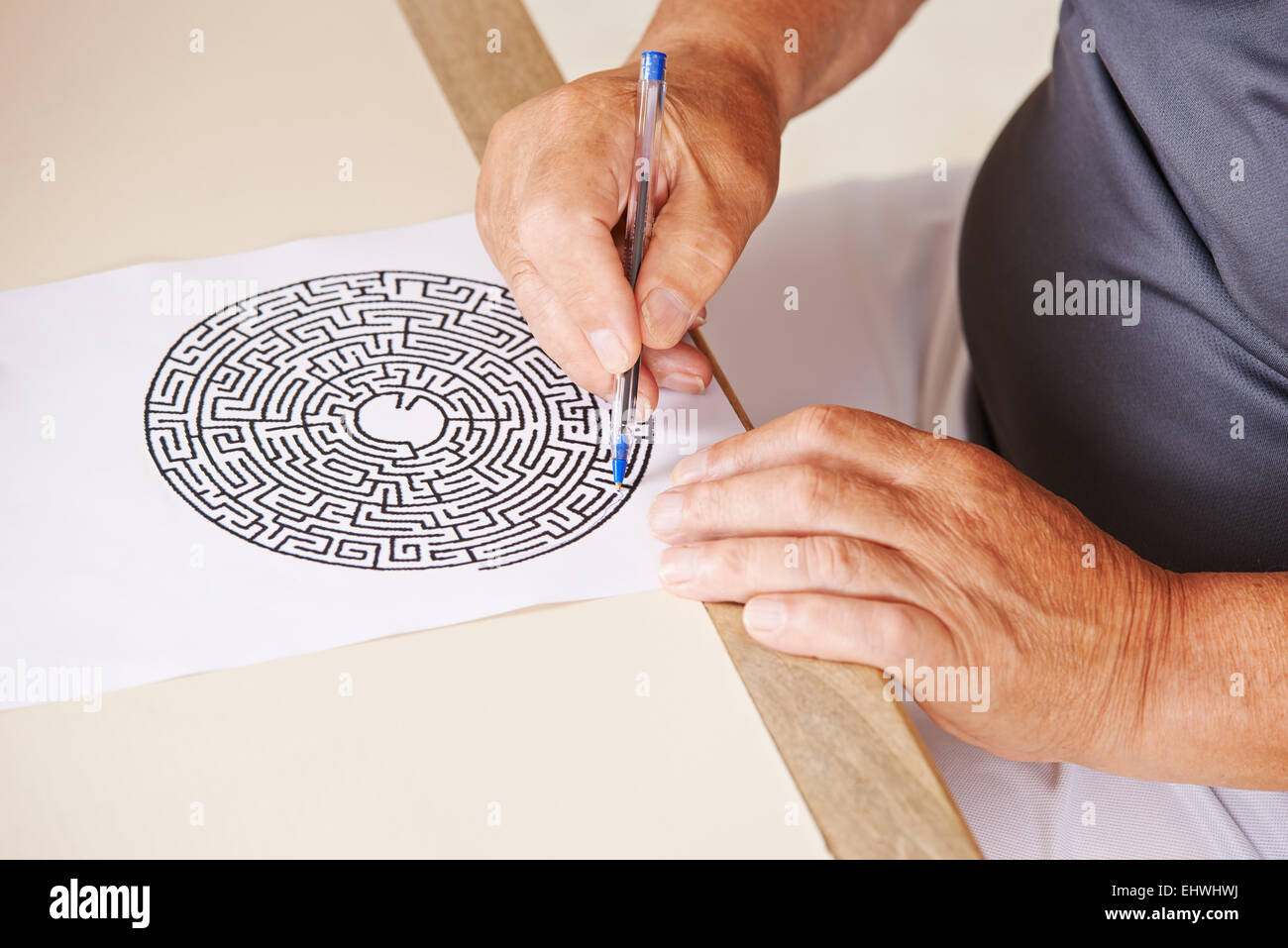 Alter Mann tun der Gedächtnistraining mit Papier Labyrinth in einem Pflegeheim Stockfoto