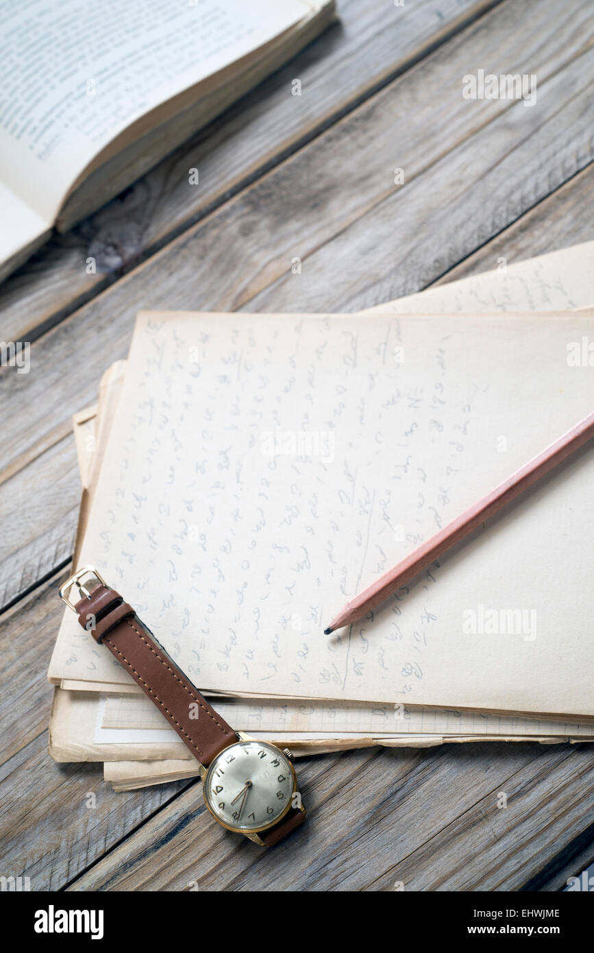 Armbanduhr, Bleistift und alte Papiere Stockfoto