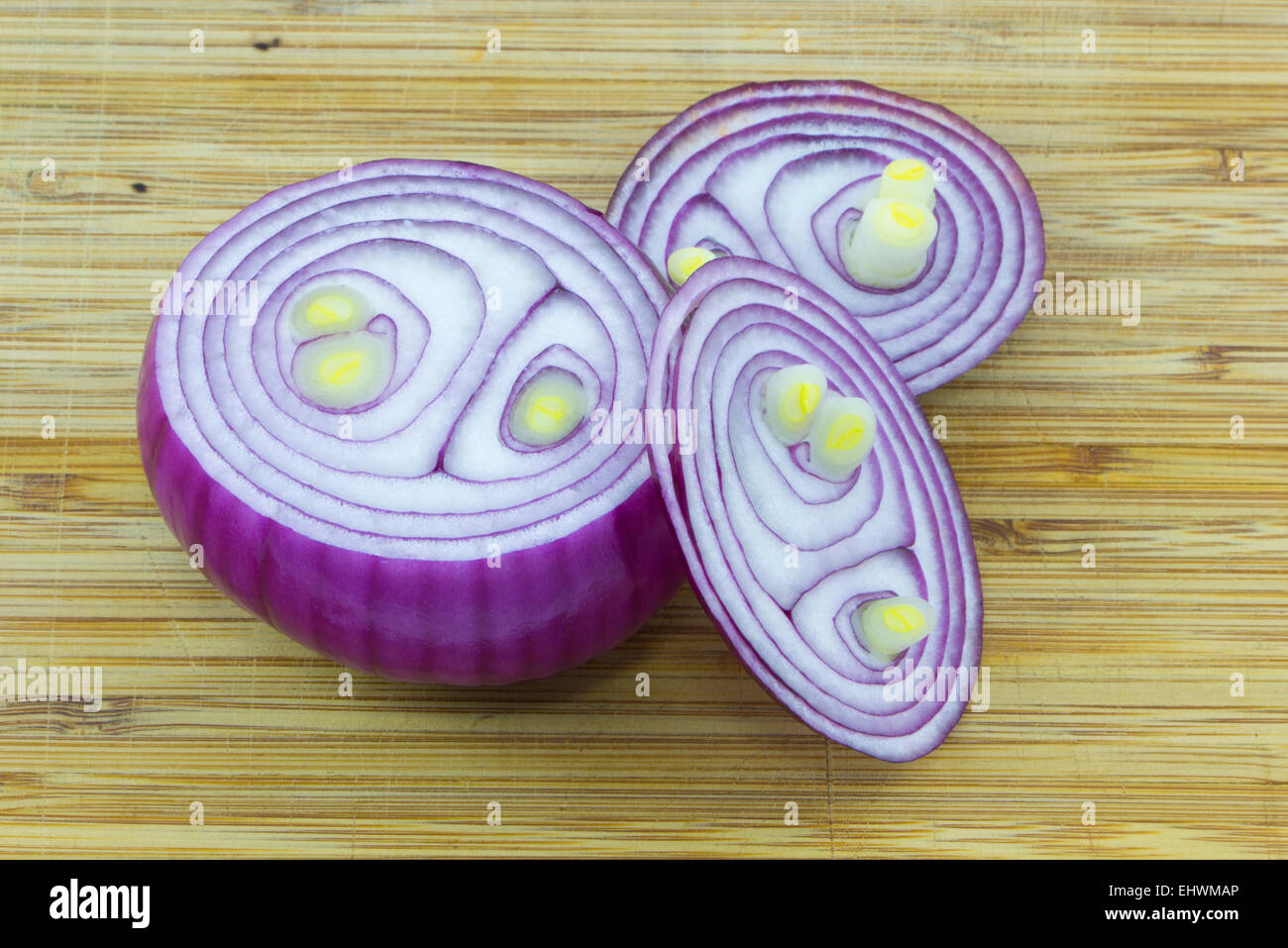 Roter Zwiebel auf hölzernen Hintergrund in drei Stücke schneiden. Stockfoto