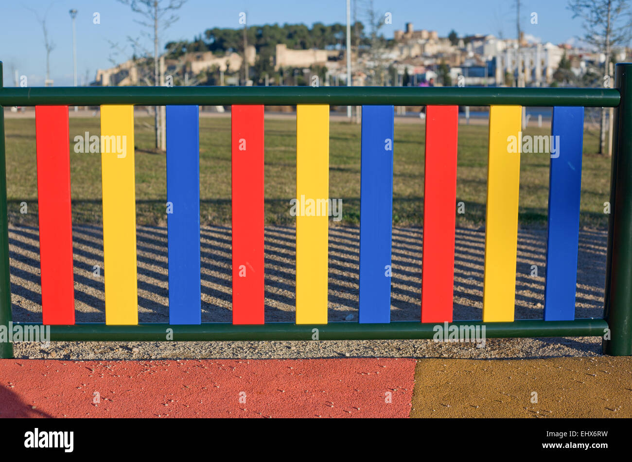 Bunte Reihen von bemalten Pfosten auf einem Spielplatz Zaun, Badajoz, Spanien Stockfoto