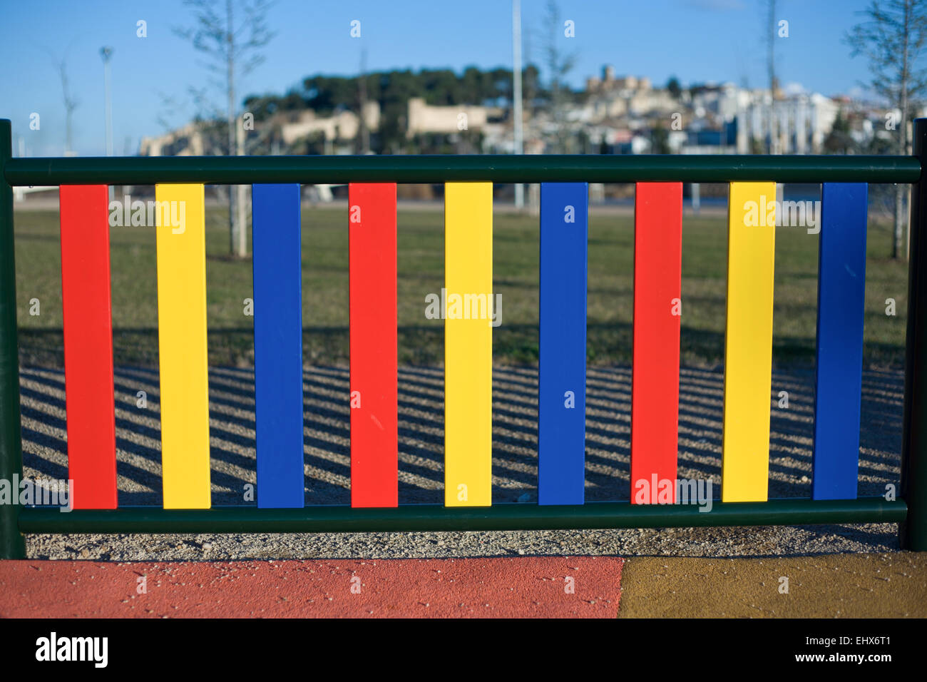 Bunte Reihen von bemalten Pfosten auf einem Spielplatz Zaun, Badajoz, Spanien Stockfoto