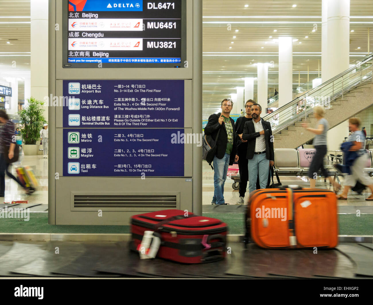 Gepäck auf das Gepäck warten Leute behaupten Karussell am internationalen Flughafen Pudong in Shanghai, China Stockfoto