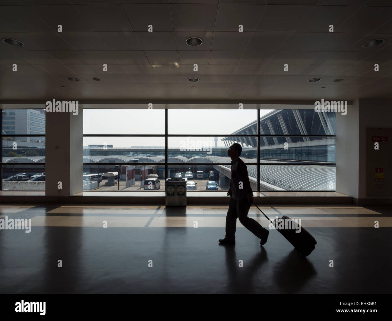 Person zu Fuß mit rollenden Koffer am Flughafen Pudong in Shanghai, China Stockfoto