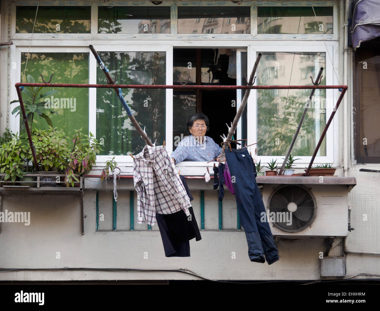 Alte chinesische Frau, die Kleidung Außerbetriebnahme die traditionelle Weise zu trocknen Stockfoto