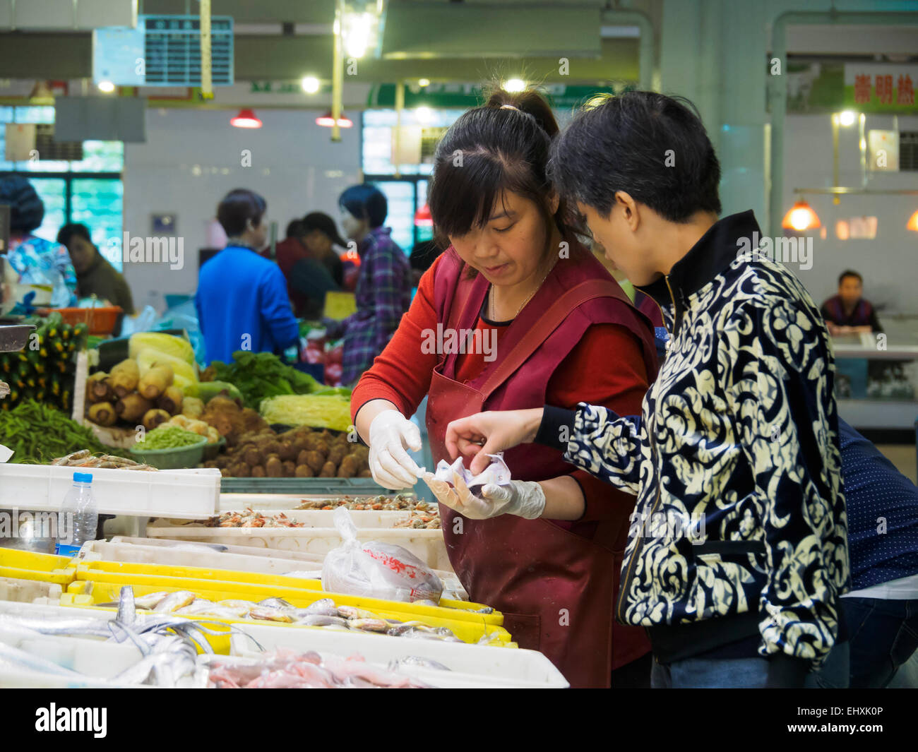 Kunden kaufen Fisch aus einem Fischhändler auf einem Markt in Shanghai, China Stockfoto