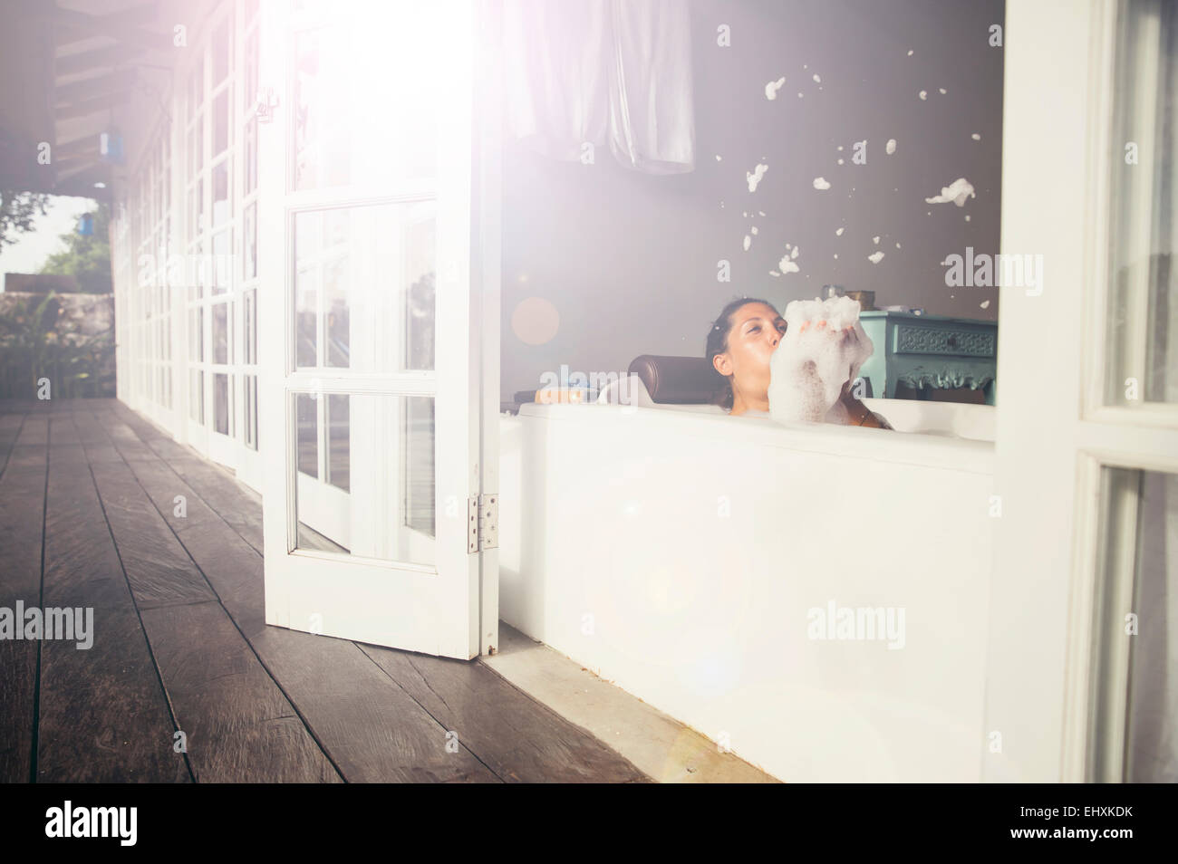 Frau in der Badewanne Schaum weht Stockfoto