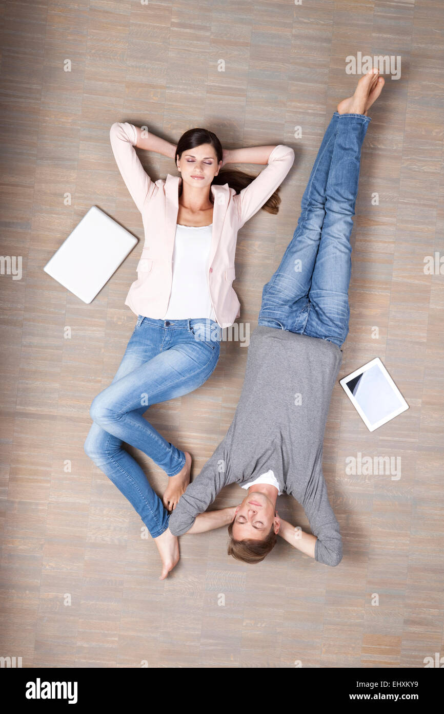 Mann und Frau mit Laptop und digital-Tablette am Boden liegen Stockfoto