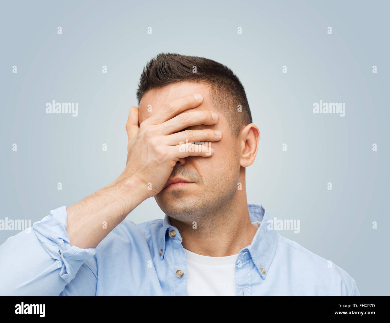 unglücklicher Mensch seine Augen mit der hand bedecken Stockfoto